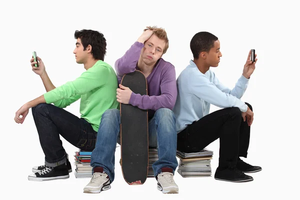 Bored teenagers sat on piles of books — Stock Photo, Image