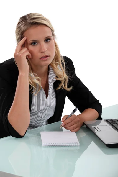 Pensive businesswoman writing notes Stock Image