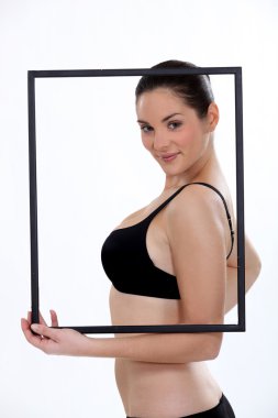 Beautiful woman in underwear behind a frame clipart
