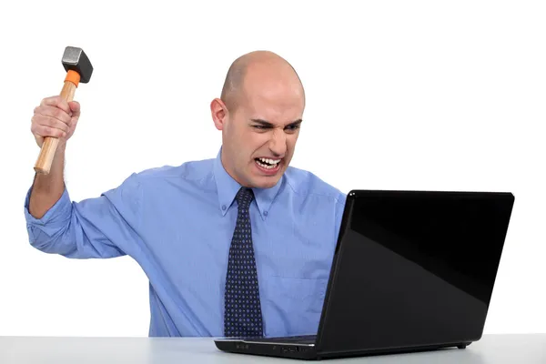 Businessman taking a hammer to his laptop — Stock Photo, Image