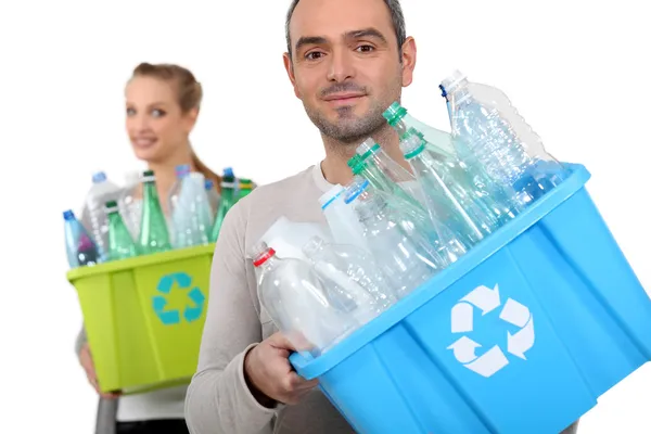 Homem e mulher reciclando garrafas de plástico — Fotografia de Stock