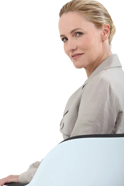 Mulher de negócios loira sentada em uma cadeira — Fotografia de Stock