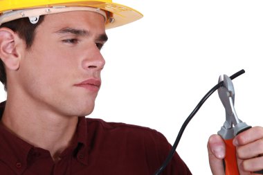 Man carefully cutting electrical wire clipart