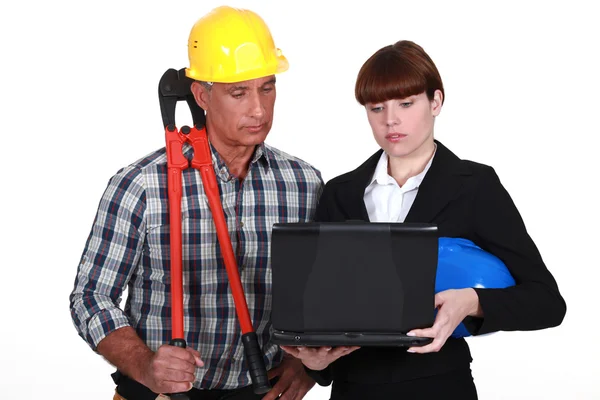 An architect and a foreman looking at a computer. — Stock Photo, Image
