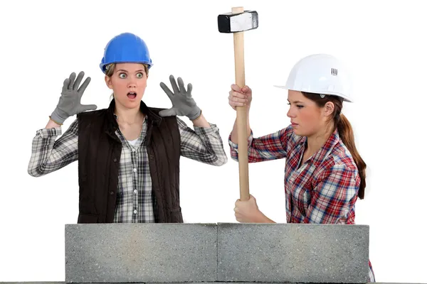 Femmes détruisant un mur de briques — Photo