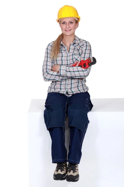 Young female apprentice posing cross-armed with adjustable spanner — Stock Photo, Image