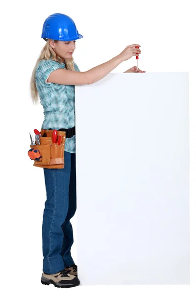 Craftswoman fixing an ad board — Stock Photo, Image