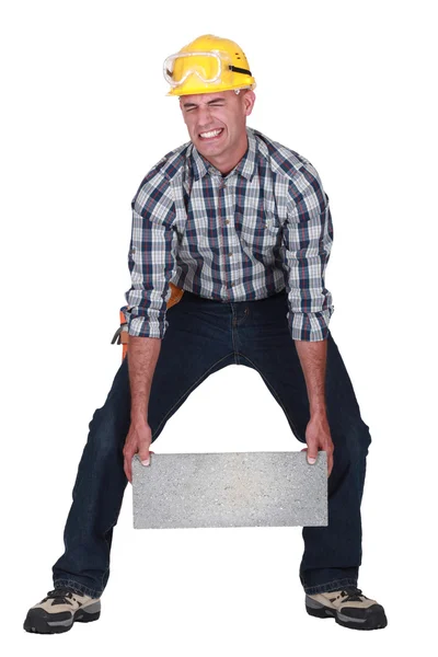 Man struggling to carry building block — Stock Photo, Image