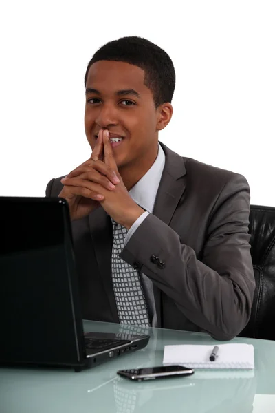 Heureux homme d'affaires noir assis à son bureau — Photo