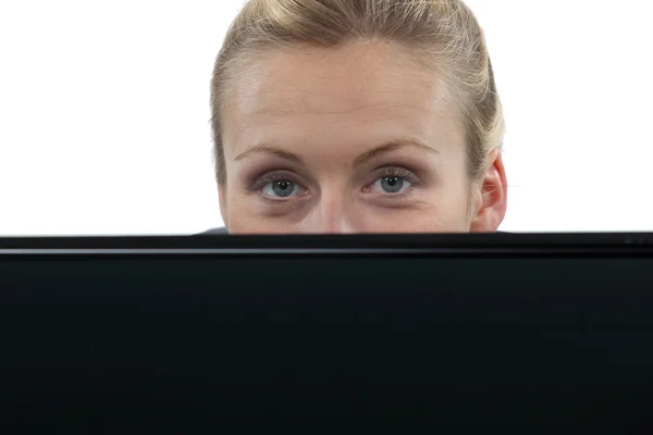 Woman hiding behind laptop computer — Stock Photo, Image