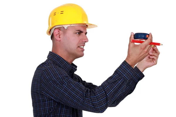 Craftsman holding a meter and looking really displeased — Stock Photo, Image