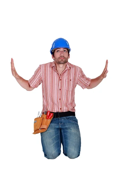 Workman kneeling on the floor, studio shot — Stock Photo, Image