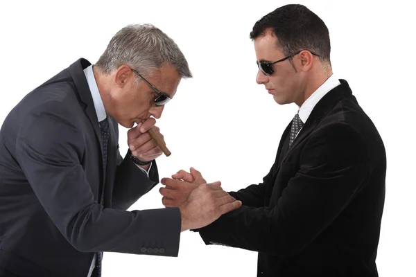 Mobster helping his boss light a cigar Royalty Free Stock Photos
