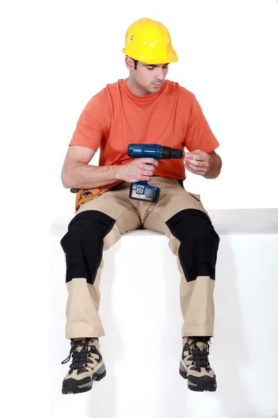 Man sat holding cordless drill — Stock Photo, Image