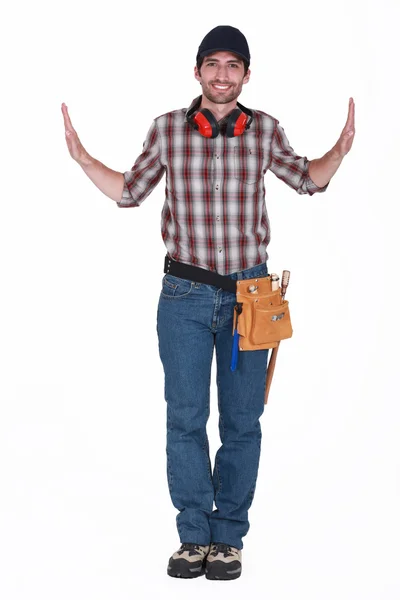 Portrait of handsome carpenter wearing cap with hands raised on either side — Stock Photo, Image