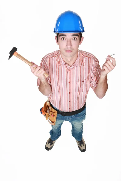 Handelaar holding een hamer en een spijker — Stockfoto