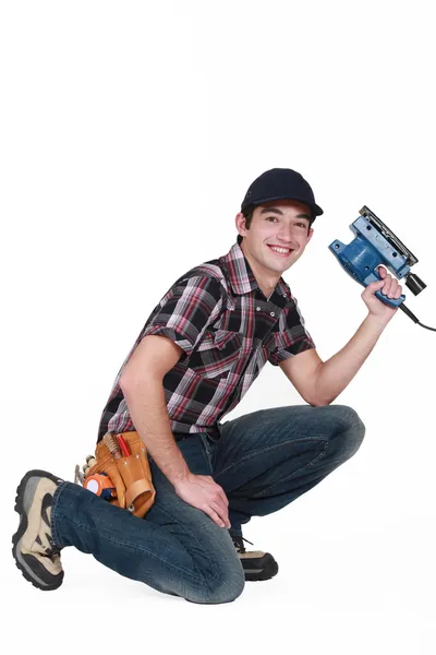 Joven sosteniendo una lijadora — Foto de Stock