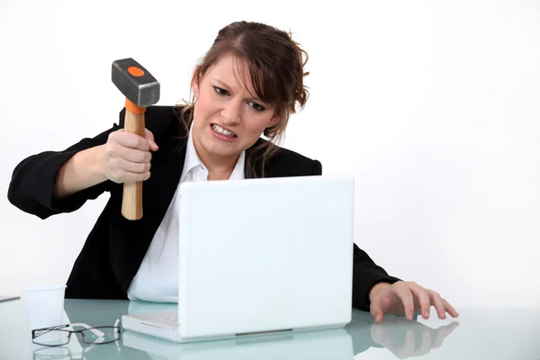 Vrouw smashing laptop met hamer — Stockfoto