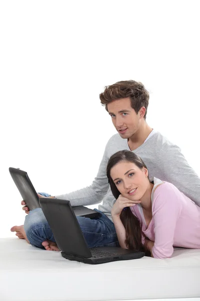 Bonito casal com laptop sentado no chão — Fotografia de Stock