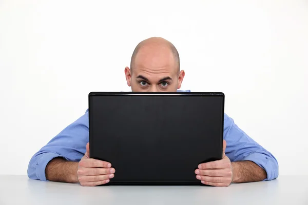 Man hiding behind laptop Royalty Free Stock Photos