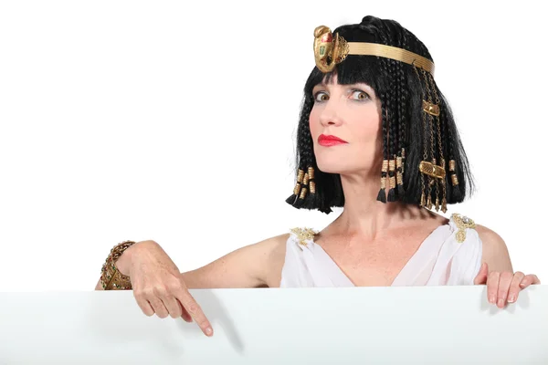 Cleópatra apontando para placa de publicidade em branco — Fotografia de Stock