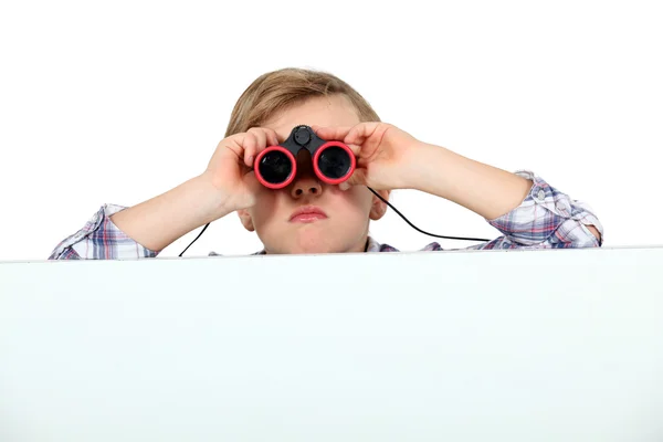 Um menino sério usando binóculos — Fotografia de Stock