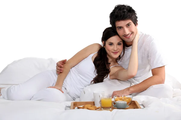 Una pareja desayunando en la cama — Foto de Stock