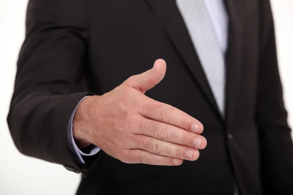 Empresário estendendo a mão para apertar as mãos — Fotografia de Stock