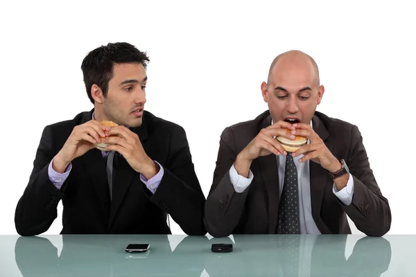 Des hommes d'affaires mangeant des hamburgers — Photo