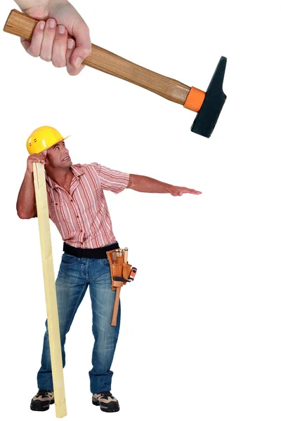 Travailleur de la construction frappé avec un marteau — Photo