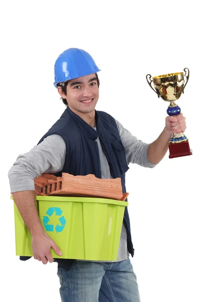 Robotnik z trofeum i kosz recyklingu. — Zdjęcie stockowe