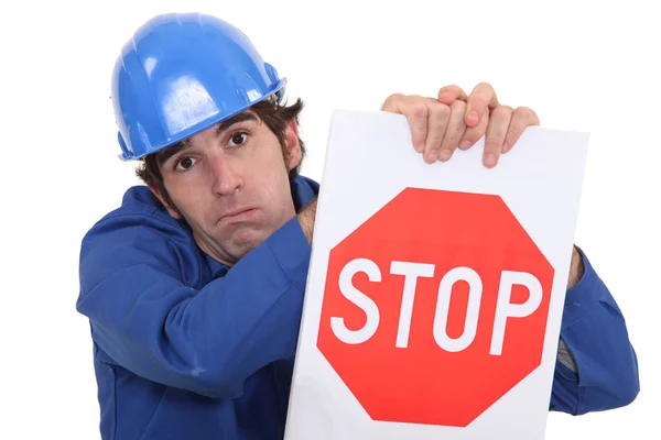 Bauarbeiter im Overall hält Stoppschild — Stockfoto