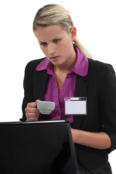 Mujer en un portátil con una placa de identificación en blanco —  Fotos de Stock