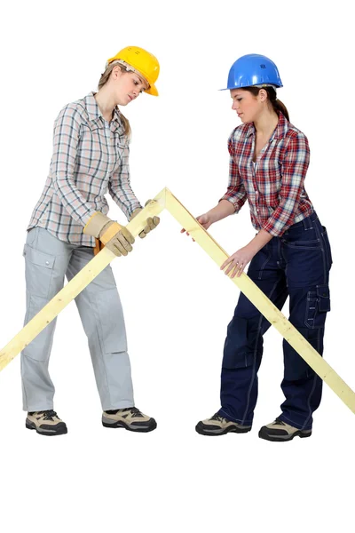 Female builders with a wooden apex — Stock Photo, Image
