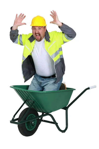 Trabalhador sentado em um carrinho de mão gritando — Fotografia de Stock