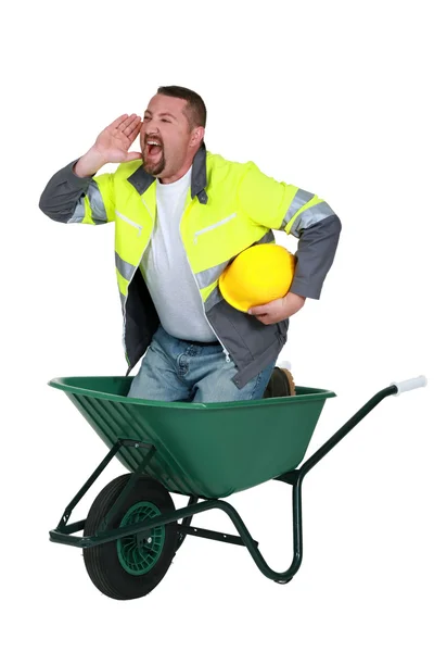 Mason shouting whilst stood in wheelbarrow — Stock Photo, Image