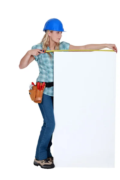 Construction worker measuring a blank board — Stock Photo, Image