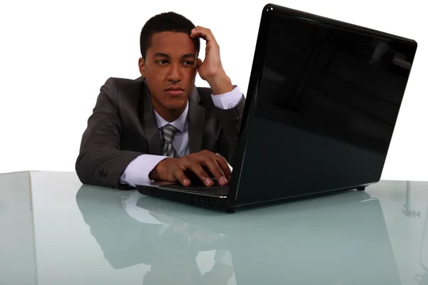 Bonito jovem gerente trabalhando no laptop — Fotografia de Stock