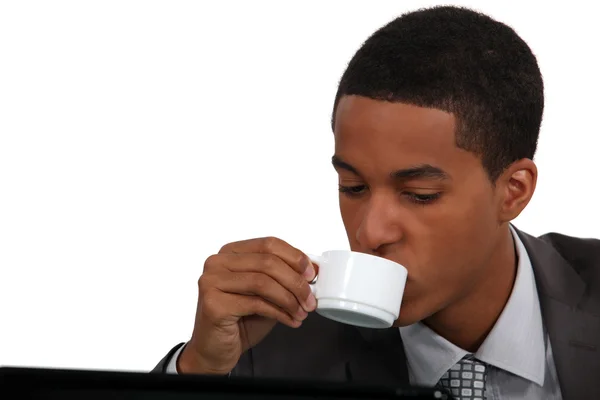 Businessman drinking coffee by laptop — Stock Photo, Image