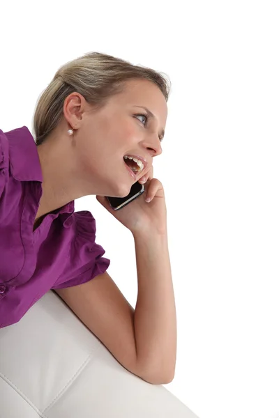 Femme assise sur le canapé et parlant sur son téléphone portable — Photo