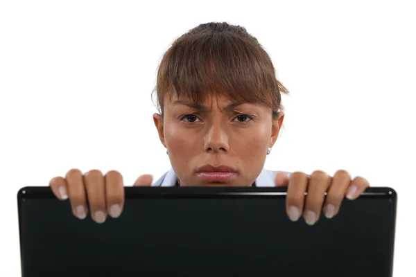 Mujer de negocios disgustada mirando por encima de la computadora portátil —  Fotos de Stock