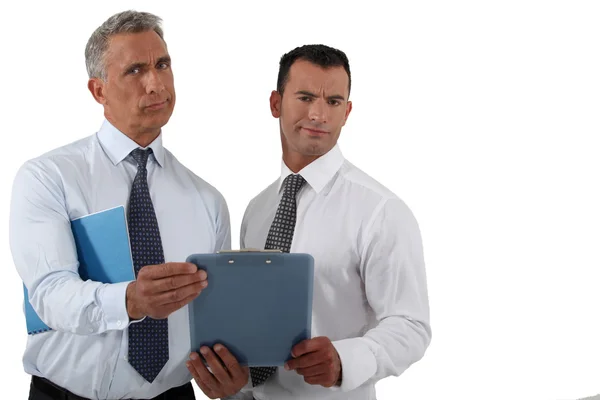 Two frowning businessmen holding clip-board — Stock Photo, Image