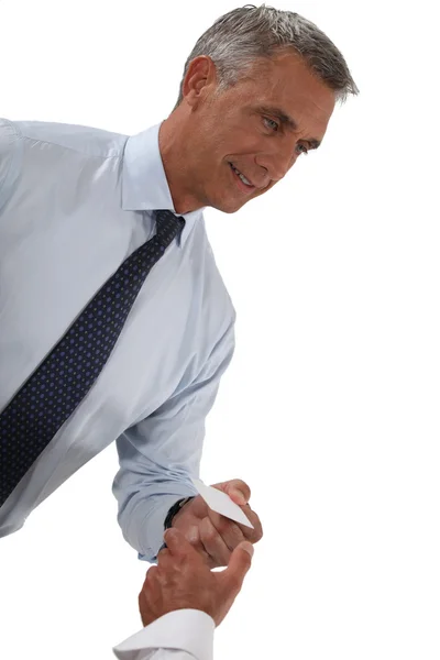 Senior businessman holding out business card — Stock Photo, Image