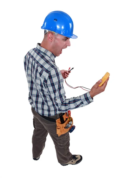 Electrician looking at his measurement tool and screaming of surprise — Stock Photo, Image