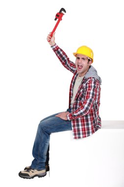 Angry tradesman holding a pipe wrench clipart