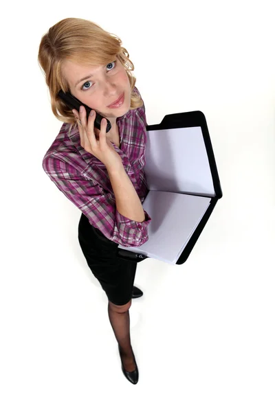 Woman on the phone with folder in hand — Stock Photo, Image