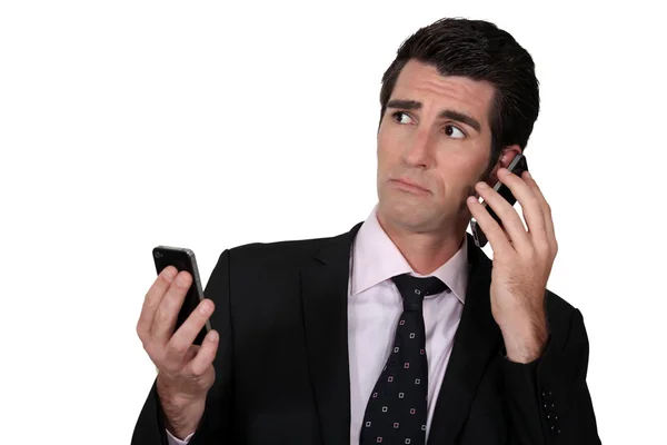 Людина з двома телефонами — стокове фото