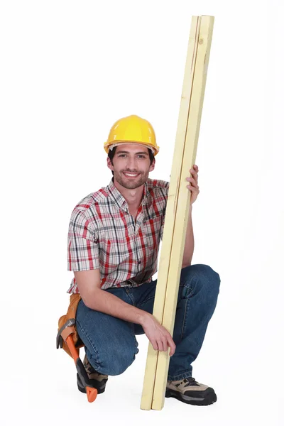Carpinteiro posando com madeira — Fotografia de Stock