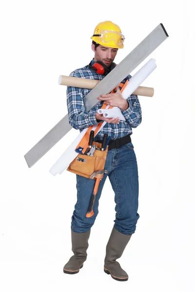 Builder struggling to carry equipment — Stock Photo, Image