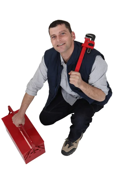 Tradesman with a pipe wrench and toolbox — Stock Photo, Image